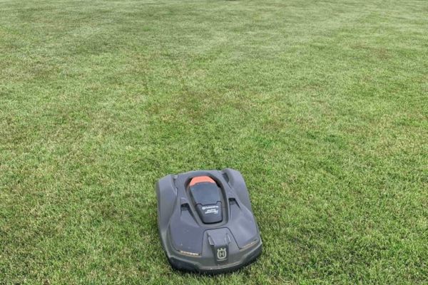 An automated lawn mower working in a yard