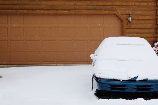 Snowy driveway with snow on top of car